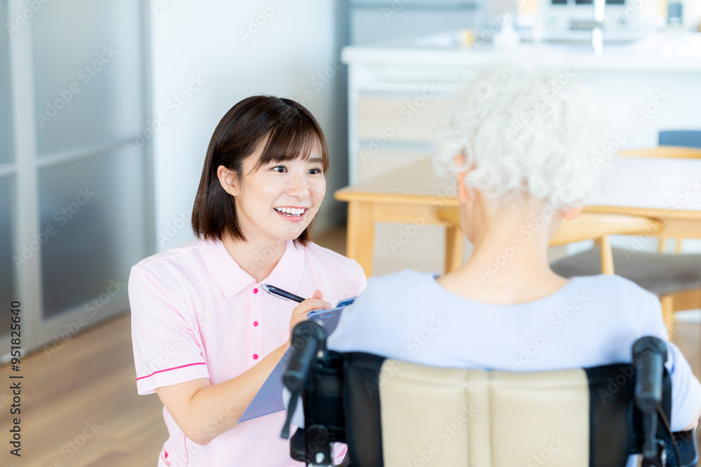 Fototapeta premium 車椅子に乗った女性をサポートする介護士