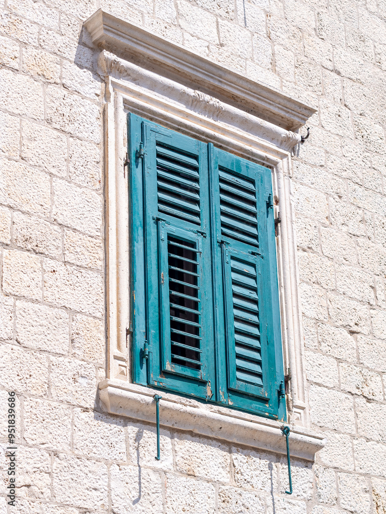 Fototapeta premium Turquoise wooden shutter on a stone building