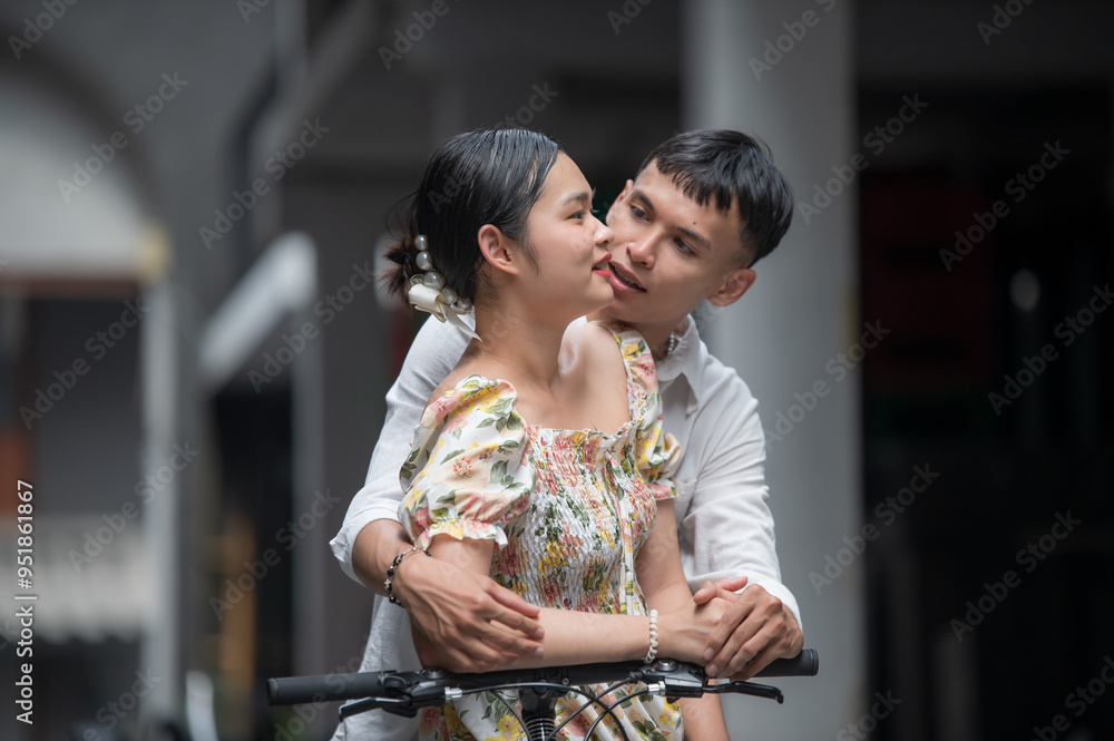 Fototapeta premium Young Asian Couple enjoying a bicycle in the city, man and woman relaxing together outside