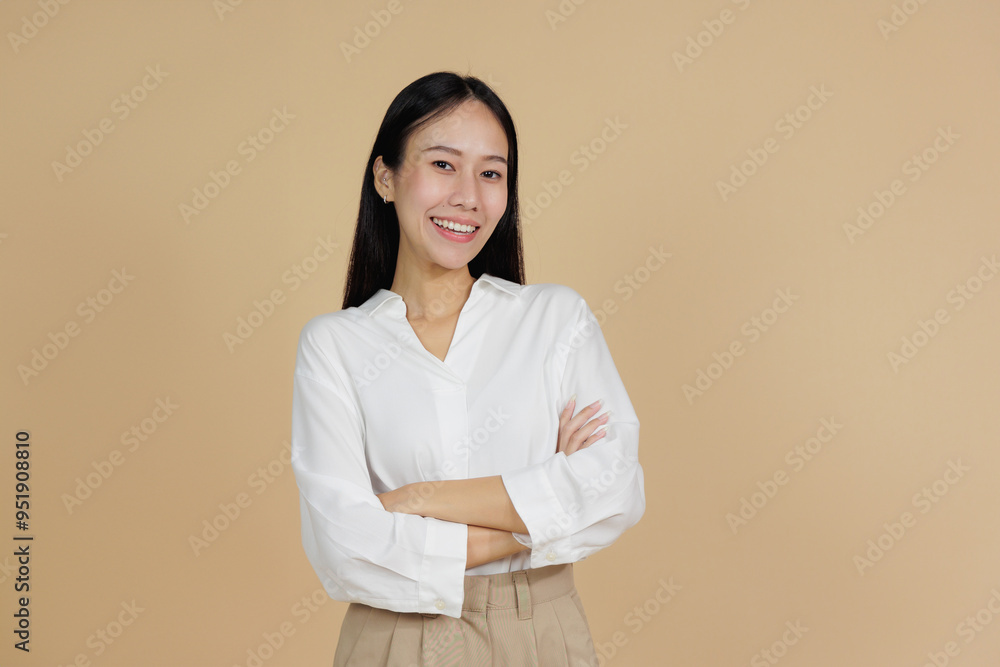 Confident Smiling Woman with Arms Crossed, Beige Background Confident Smiling Woman with Arms Crossed, Beige Background