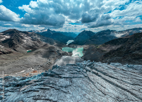 Aerial view of the Fellaria glacier in Valmalenco, Sondrio, Lombardy. Italy. Ice cliff, rock face with waterfalls and lake. Marson glaciological trail. Climate change, melting glaciers