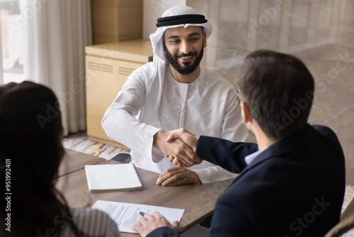 Photography Happy confident young Arabian company owner shaking hands with European colleagu