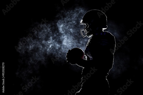 Silhouette dark scene of American football player in helmet holding football.  Fog and team. Concept