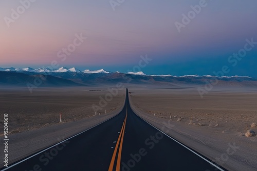 Expansive Road Journey Through Vacant Valleys and Peaks Under a Dusk Sky