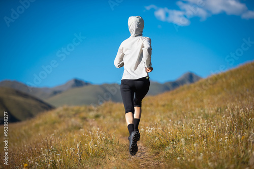 Fitness woman runner running in grassland photo