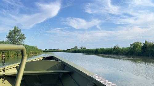 Boat tour on the Italian River. Scene features a variety of plants thriving at the water's edge, highlighting the region's rich biodiversity