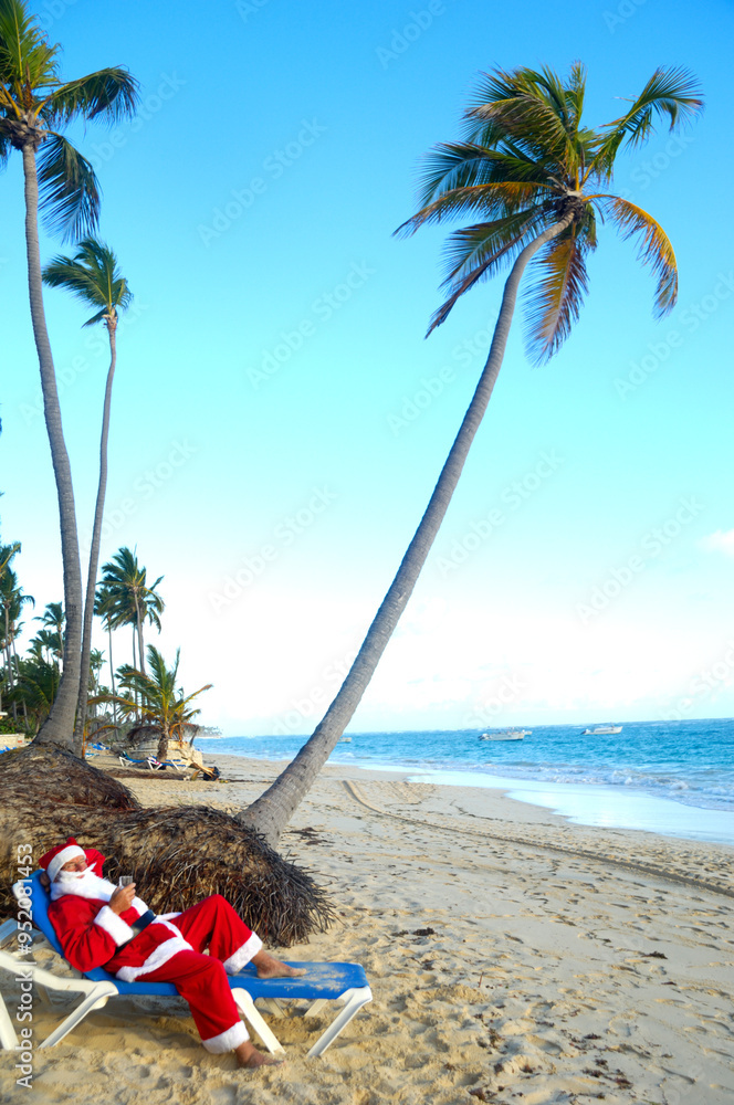 Naklejka premium Santa Claus is on vacation on a tropical beach.