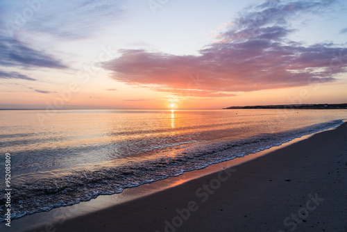 Fototapeta Naklejka Na Ścianę i Meble -  Orange sunrise with colorful clouds at the baltic sea in a bay near Glowe