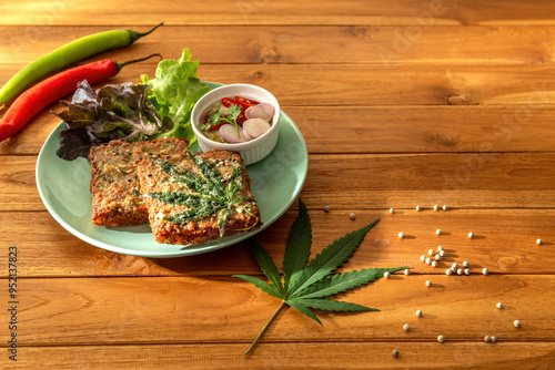 Dish of hot delicious cannabis fried minced pork toat menu with sweet and sour sauce on wooden table background. Copy space text. Eatable decor recipe local international food herb for concept photo