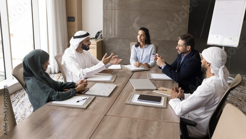 Photography Arab and Hispanic business leaders discussing project strategy, company management, talking at large meeting table