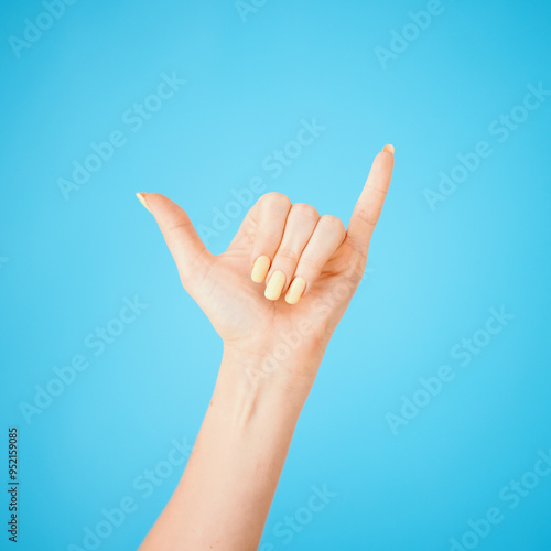 Photography Hand, gesture and shaka with model in studio on blue background feeling carefree closeup
