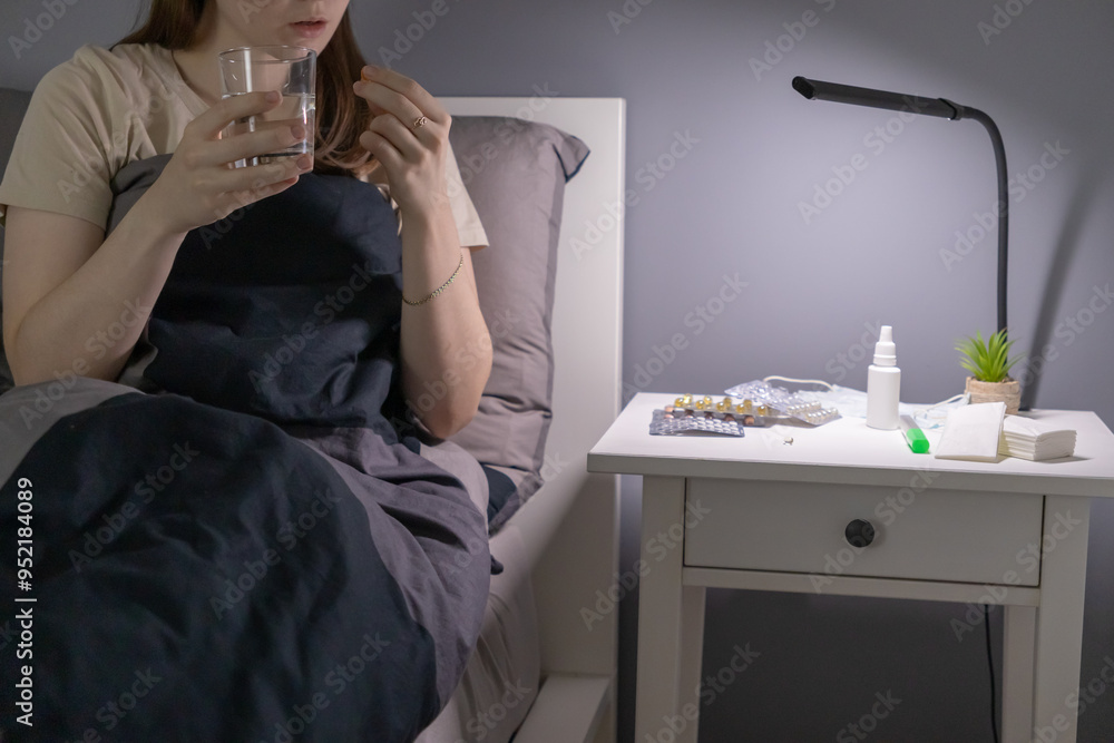 A sick woman takes pills at home. High temperature. Cold. Influenza. Recovery, illness, disease. A sick woman takes pills at home. High temperature. Cold. Influenza. Recovery, illness, disease.