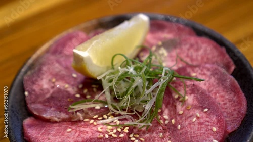 Slice of beef ox tongue gyutan lemon Japanese yakiniku bbq food 4k photo