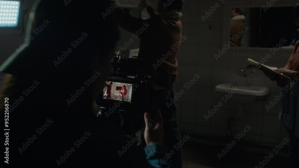 Group of three diverse students from cinematography college preparing movie set for shooting, adjusting lights and video camera, working on graduate project Group of three diverse students from cinematography college preparing movie set for shooting, adjusting lights and video camera, working on graduate project