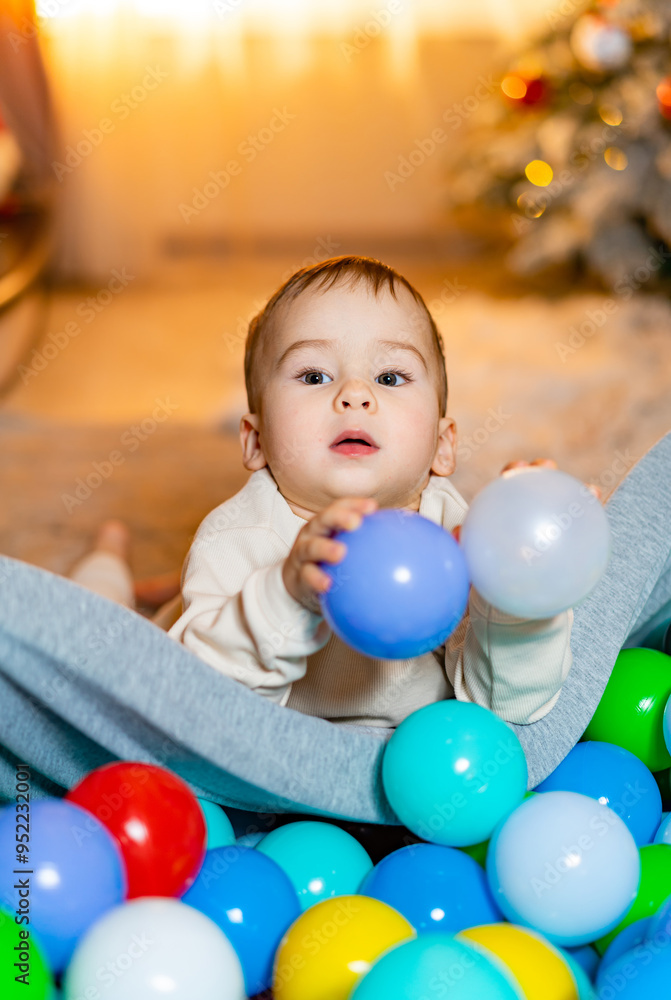 Baby playing with colorful balls in a cozy indoor setting. A curious baby explores a pile of colorful balls while lounging in a cozy living space during a warm, joyful moment. Baby playing with colorful balls in a cozy indoor setting. A curious baby explores a pile of colorful balls while lounging in a cozy living space during a warm, joyful moment.