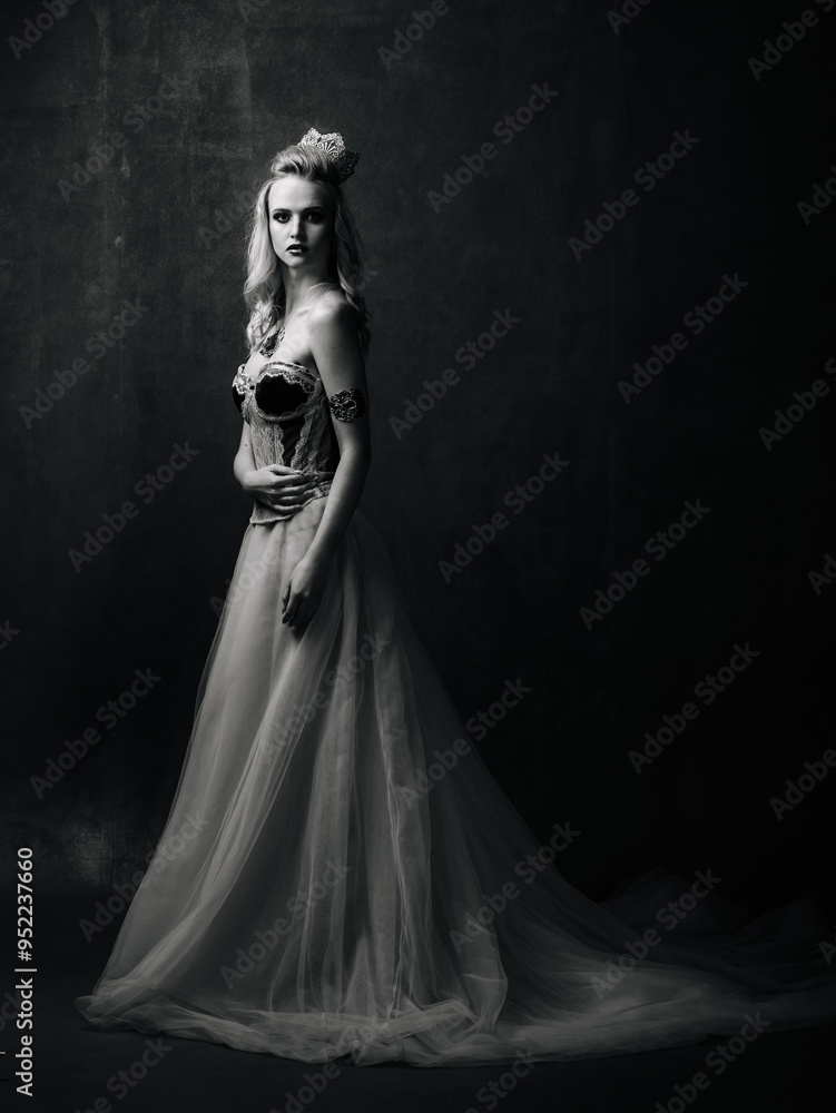 Elegant woman in a flowing gown posing against a dark backdrop. A graceful woman stands poised in a beautiful gown Elegant woman in a flowing gown posing against a dark backdrop. A graceful woman stands poised in a beautiful gown