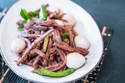 Traditional Korean Jangjorim: Soy-Braised Quail Eggs and Shredded Beef Served on a White Plate with Table Setting photo