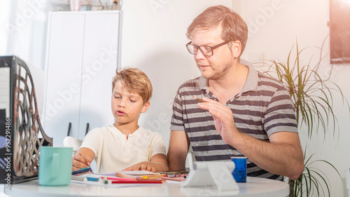  father helps the child to study and do homework for school