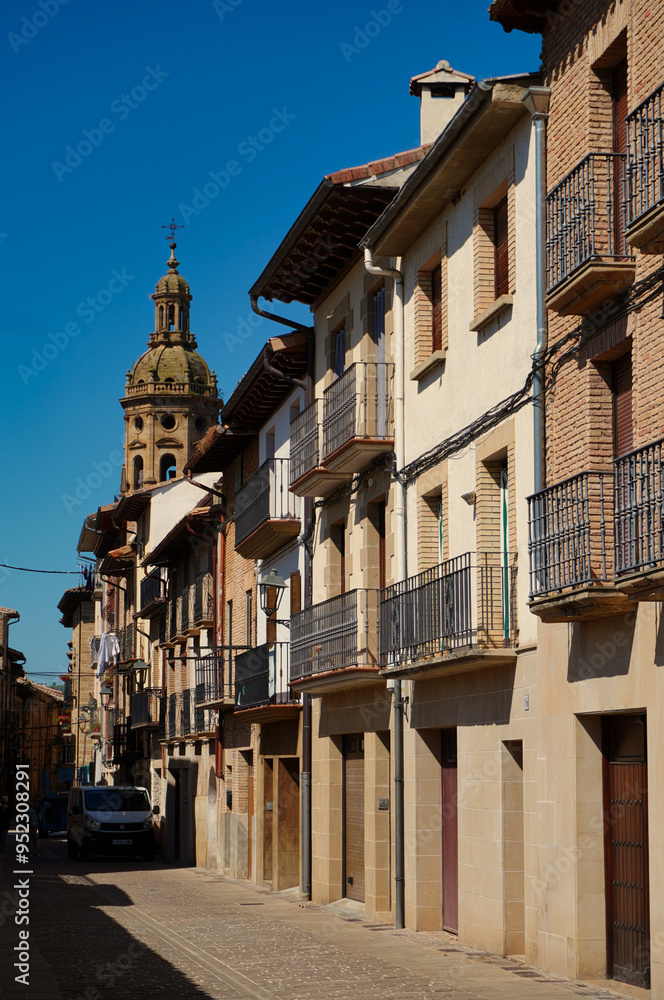 Obraz premium Puente de La Reina, Navarra. The tower of the church of Santiago el Mayor rises, immense, over the roofs of the town