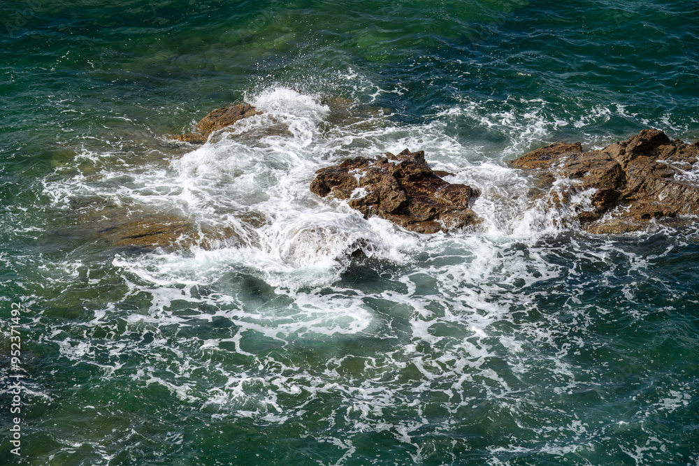 waves splashing and water spray over the rocks in the sea waves splashing and water spray over the rocks in the sea