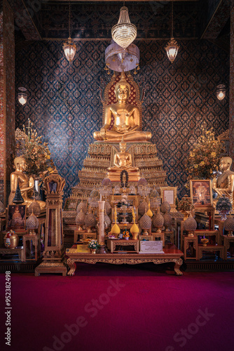 Thailand, August 11, 2024, Wat Phitchaya Yatikaram Worawihan, Golden Buddha statue surrounded by ornate decorations in a peaceful temple setting during afternoon light