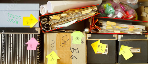 messy file folders and storage boxes in a cluttered office bookshelf,red tape, bureaucracy,overworkd,,business concept,free copy space. photo