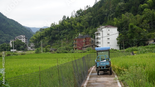 Tableau sur toile Chinese ricefield with blue car in countryside surrounded by mountains in Qingti