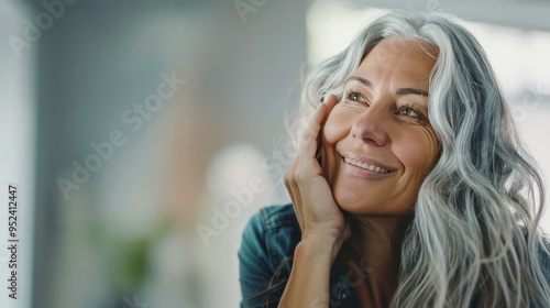 A peaceful close-up of a mature woman’s face, showcasing her gentle smile and the dignity of aging.  photo