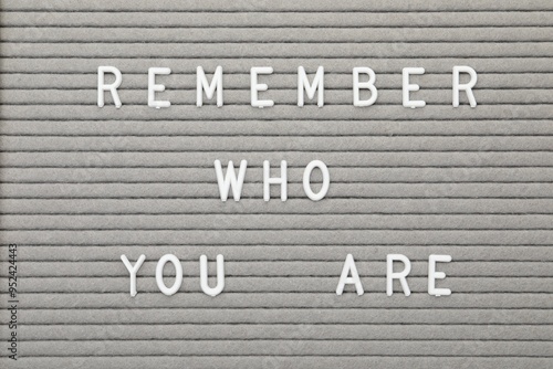 Letter board with phrase Remember who you are as background, top view