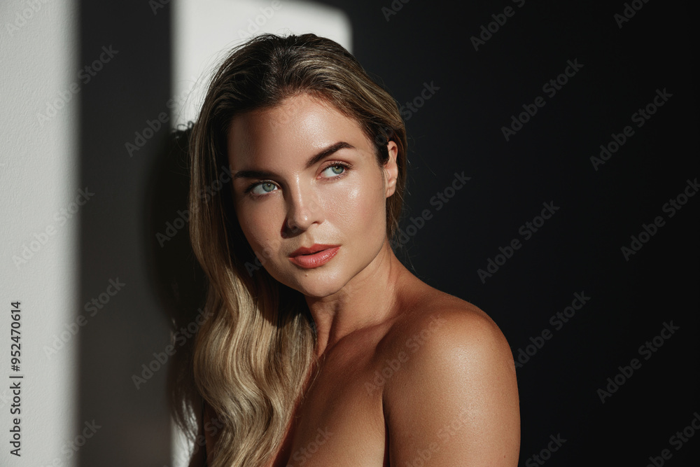 Naklejka premium Portrait of young woman with long blonde hair in sunlight