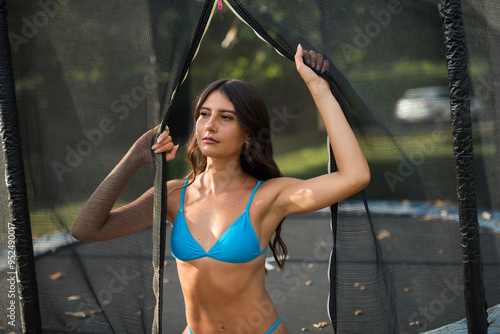 hot brunette in blue bikini at pool photo