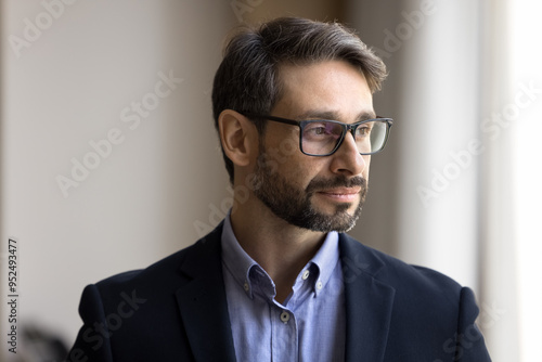 Thoughtful handsome middle aged business man in stylish glasses looking at window away, thinking on professional challenge, company success, leadership, planning future projects