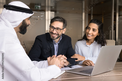 Photography Happy Latin couple meeting with Arabian real estate seller, talking to consultan