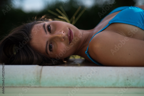 hot brunette in blue bikini at pool photo