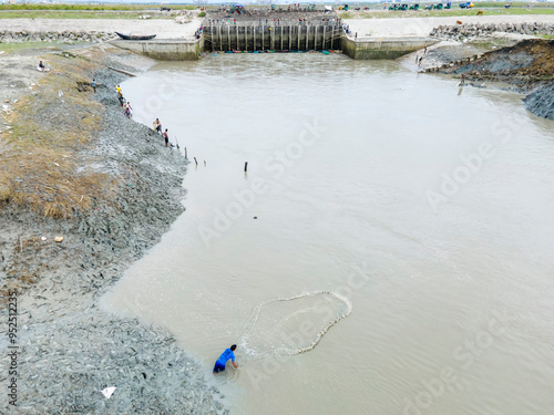 Aerial view of People are catching fish with hand-made nets in front of the switch guide in Economics zone area of ​​Mirsarai upazila of Chittagong division of Bangladesh.
 photo