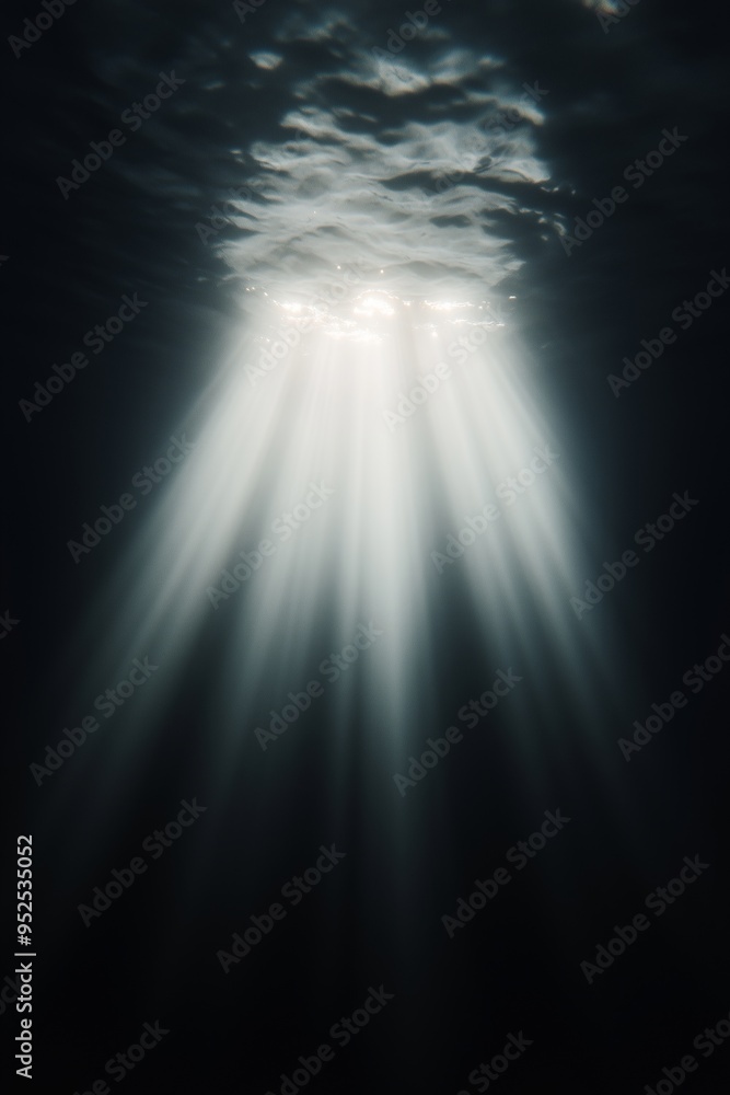 Obraz premium Light rays penetrating dark ocean water from surface. Underwater, deep sea concept. Image for marine documentary and ocean poster. With copy space.
