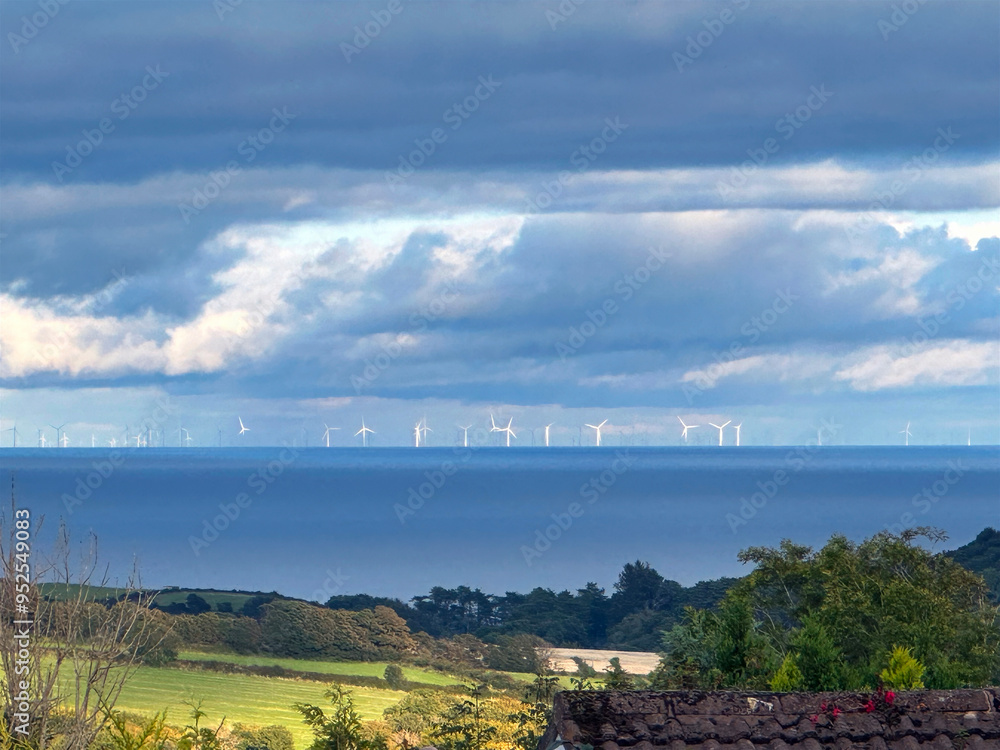 Obraz premium Distant wind farm on the English coast viewed across the Irish Sea and the Isle of Man