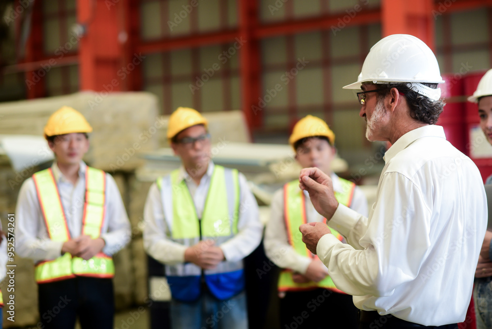 Professional Caucasian manager engineer wearing safety hardhat is training industry worker, workshop factory operator, mechanical engineering team production in heavy industrial manufacture factory. Professional Caucasian manager engineer wearing safety hardhat is training industry worker, workshop factory operator, mechanical engineering team production in heavy industrial manufacture factory.