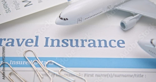 Travel insurance and service concept : Top view of travel insurance application form, a boarding pass, a passport and air plane. Travel insurance covers costs and losses associated with traveling.