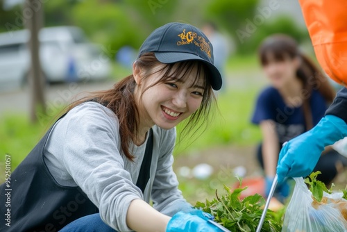 A group of Japanese volunteers picking up litter in a city park, with their hands carefully holding trash grabbers and placing waste into a biodegradable trash bag, smiles on their faces as they work photo