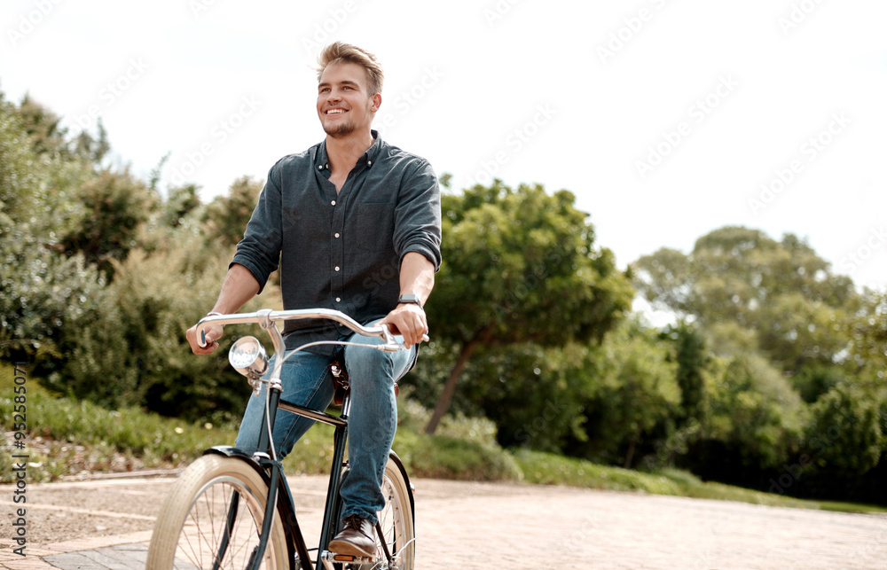 Obraz premium Happy man, outdoor and bicycle ride in park for commute, urban journey and sustainable travel. Male person, smile and bike in city for eco friendly transport, physical activity and exercise in nature