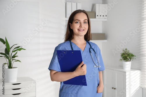 Portrait of professional nurse with clipboard in clinic