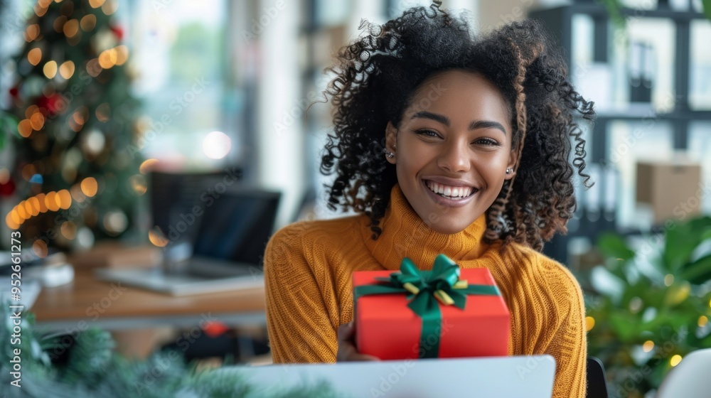 A woman is holding a red box with a green bow on it A woman is holding a red box with a green bow on it
