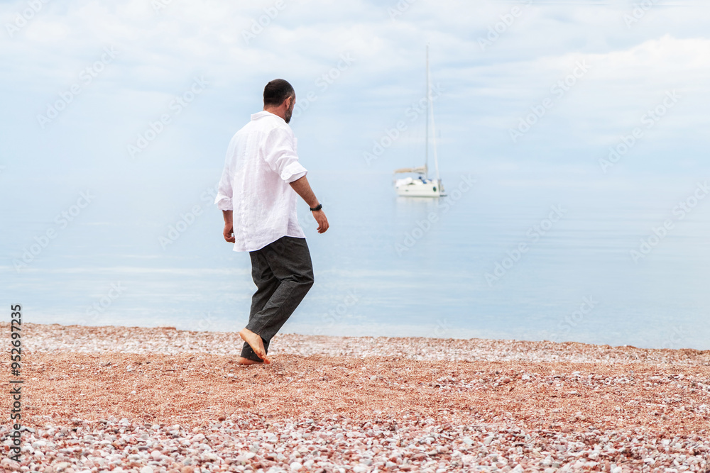 Man in a white shirt against the backdrop of the sea and a yacht. Summer baclground. Man in a white shirt against the backdrop of the sea and a yacht. Summer baclground.