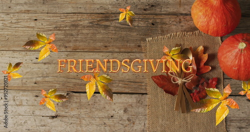 Image of friendsgiving text over cutlery and autumn leaves over wooden surface photo