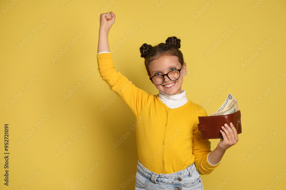 Pocket money. Cute girl with wallet and dollar banknotes on yellow background Pocket money. Cute girl with wallet and dollar banknotes on yellow background
