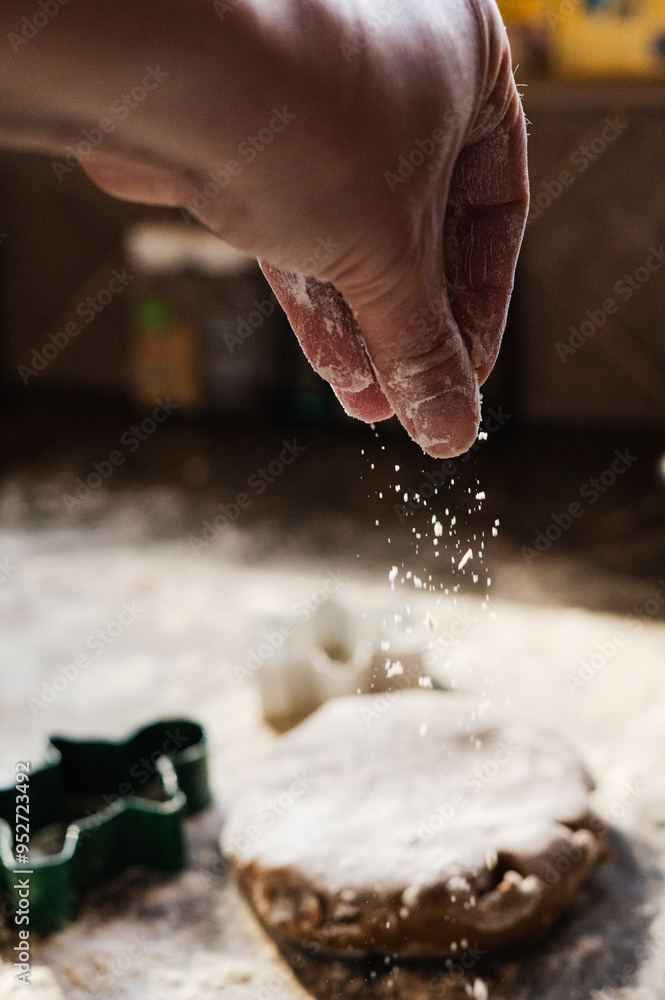 Hand dusting flour over gingerbread dough during holiday baking Hand dusting flour over gingerbread dough during holiday baking