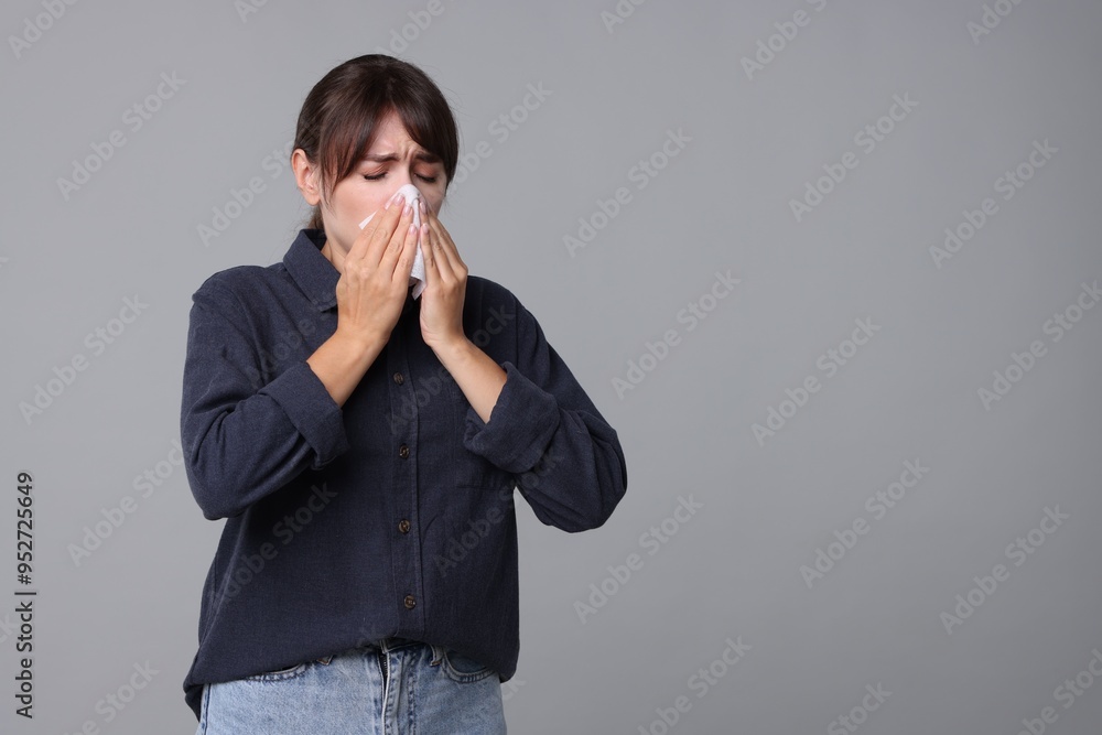 Woman with napkin suffering from sinusitis on grey background. Space for text Woman with napkin suffering from sinusitis on grey background. Space for text