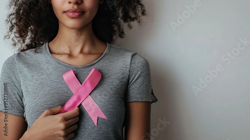 Pink Ribbon Held in Hand Against Wooden Background Cancer Day photo