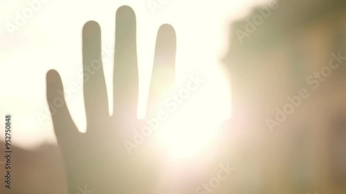 focus on hand of young black man reflected in sunset light